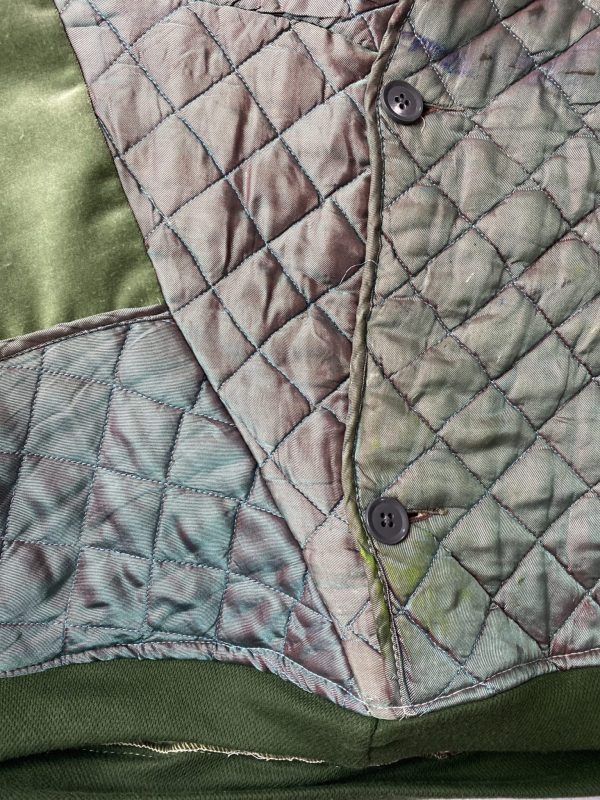 Detail shot of green upcycled batwing featuring upcycled quilted silk vintage jacket with button and green velvet