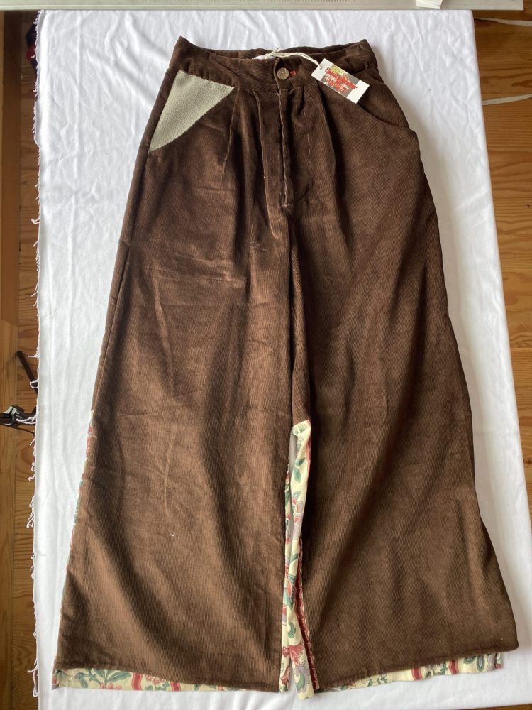 Flatlay front wide leg brown corduroy trousers with irregular wool pocket and pleating in waistbanf