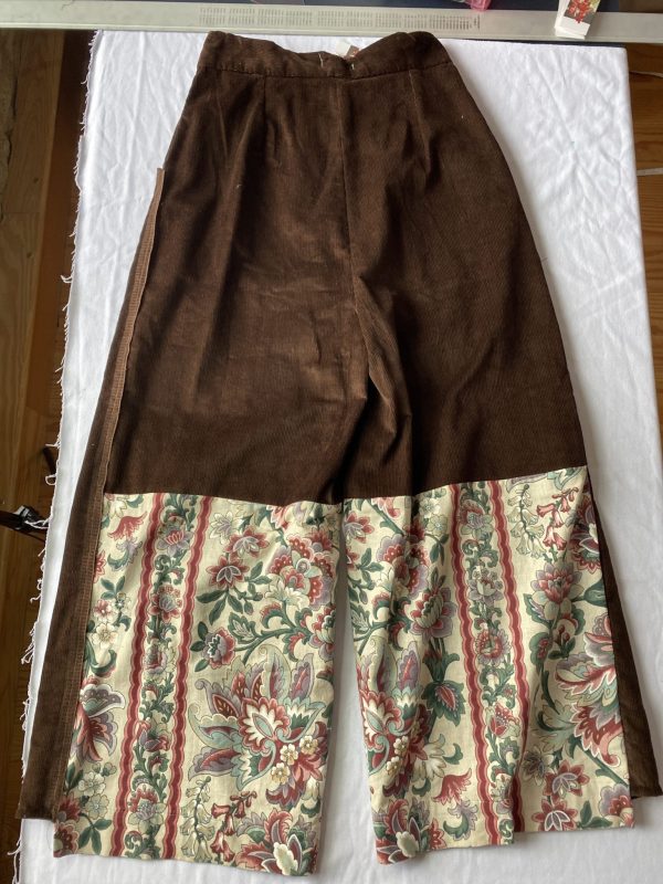 Flatlay of back of high Waisted brown corduroy trousers with vintage bottom panel