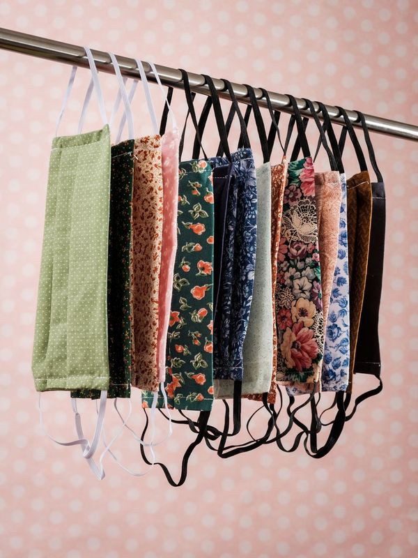 Photograph by Yousef Al Nasser Facemasks hanging on a clothing rail with elastics. They are a variety of different vintage floral patterns.