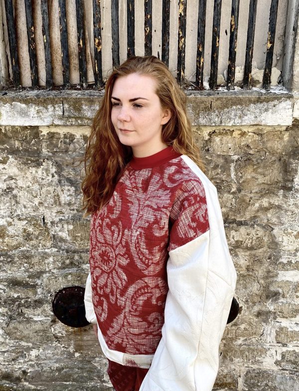 Red and white batwing jumper made from upcycled furnishing materials. Zero waste designer.
